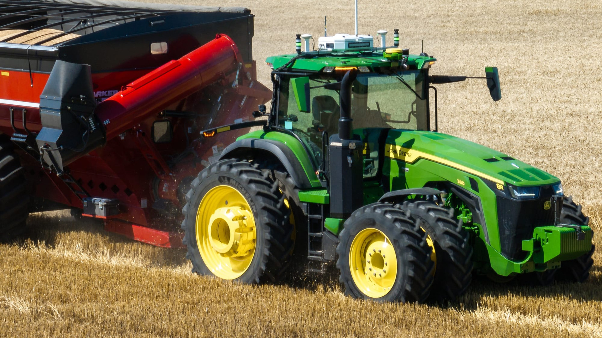 PTx Trimble OutRun autonomous grain cart kit working alongside a combine at harvest