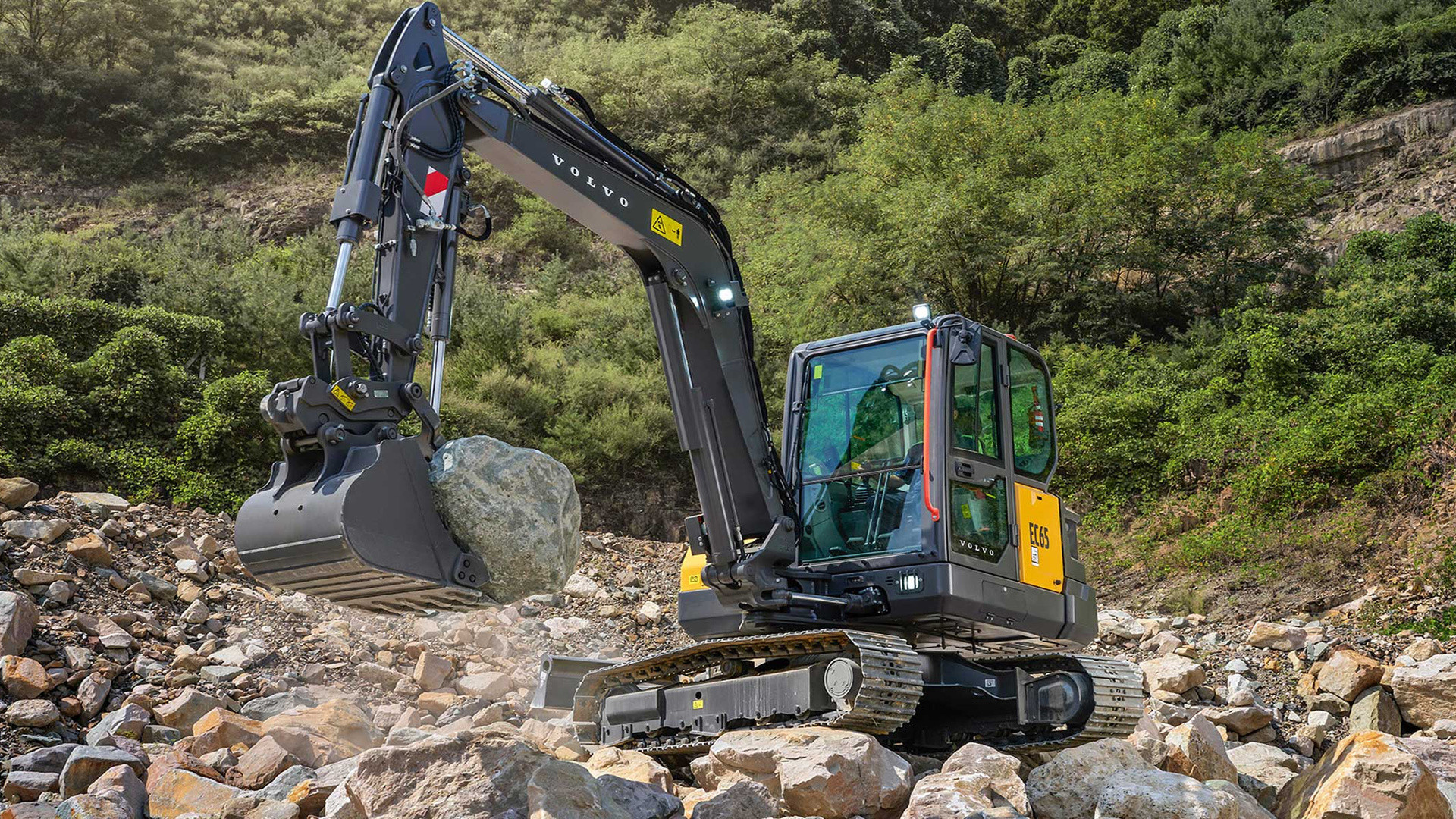 Volvo EC65 compact excavator working in a rock quarry